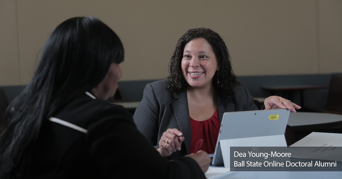 Alumni Dea Young-Moore talking with student Text: Dea Young-Moore, Ball State Online Doctoral Alumni bottom right of image.