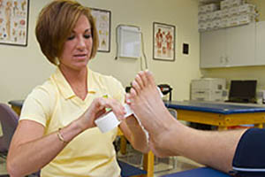 Michelle Lamb wrapping an athlete's foot