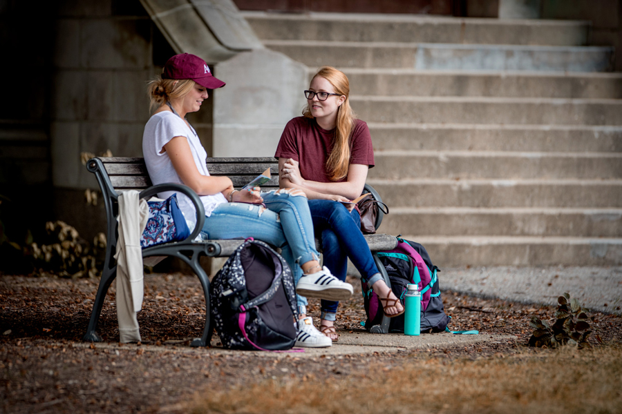 two students seated, talking