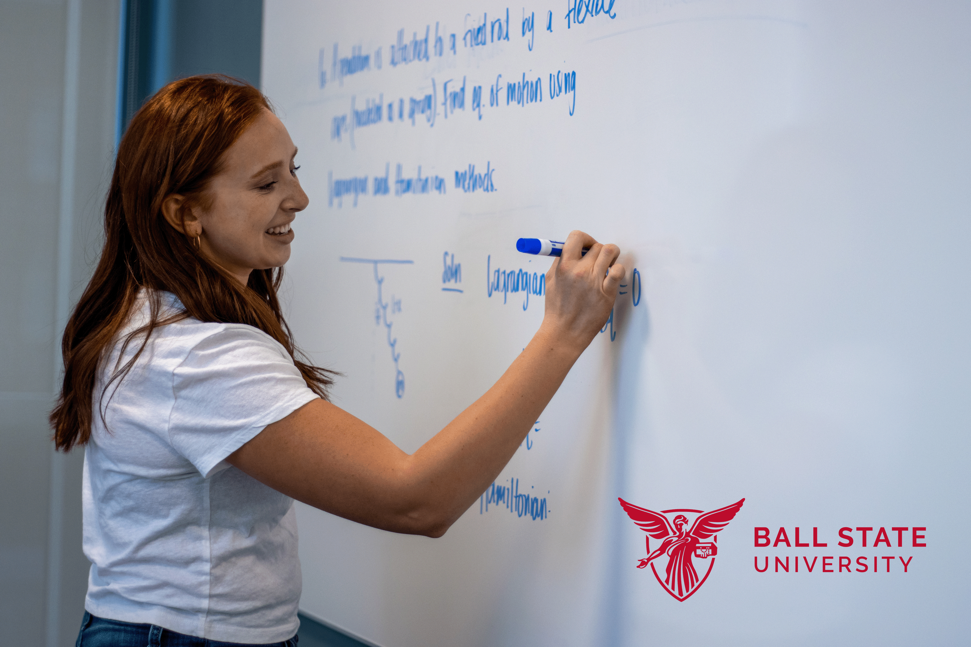 Lindsey Herrara solving physics problem on white board