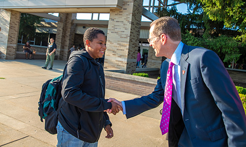 President Mearns shakes student's hand