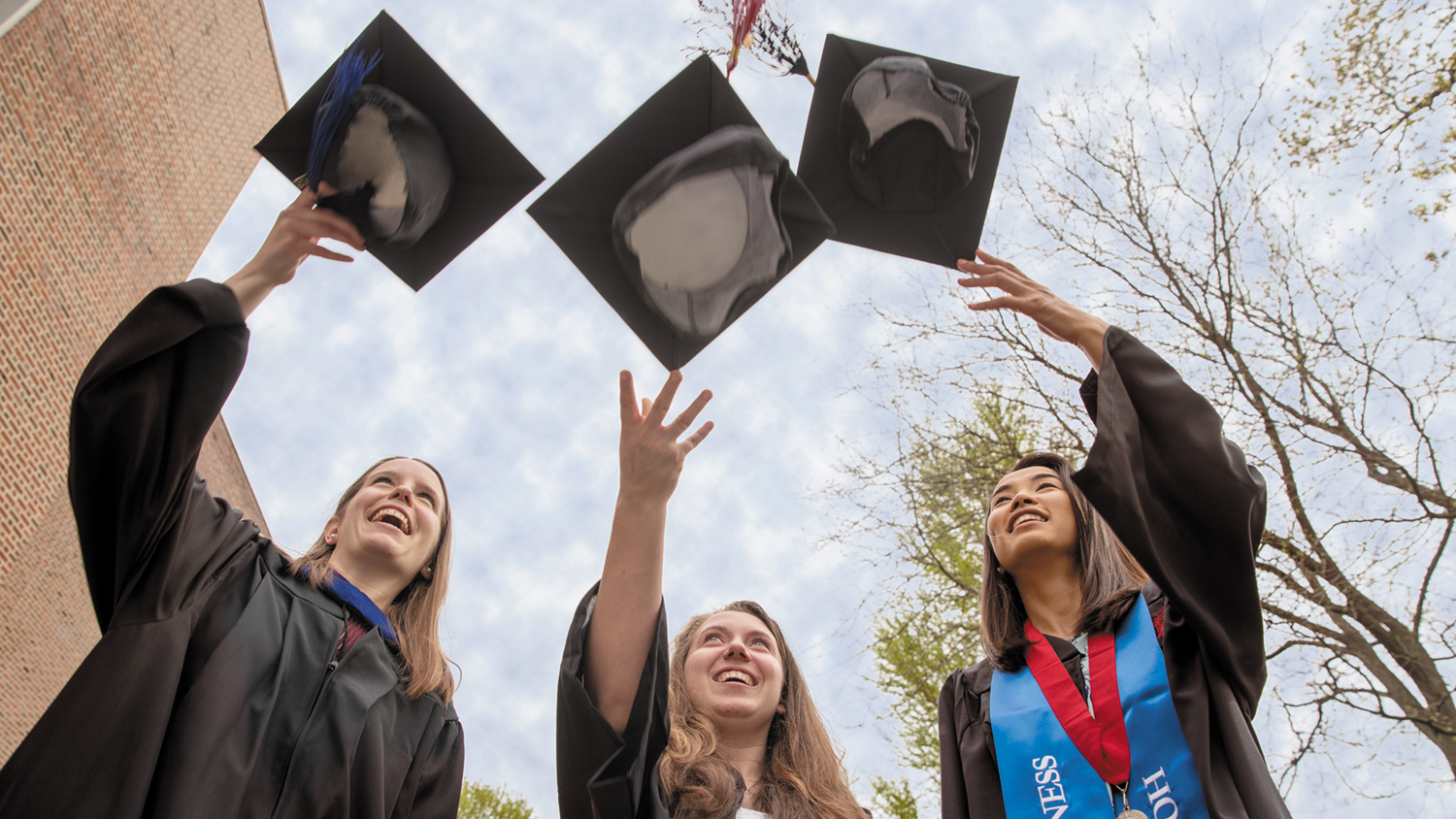 Three graduates celebrating