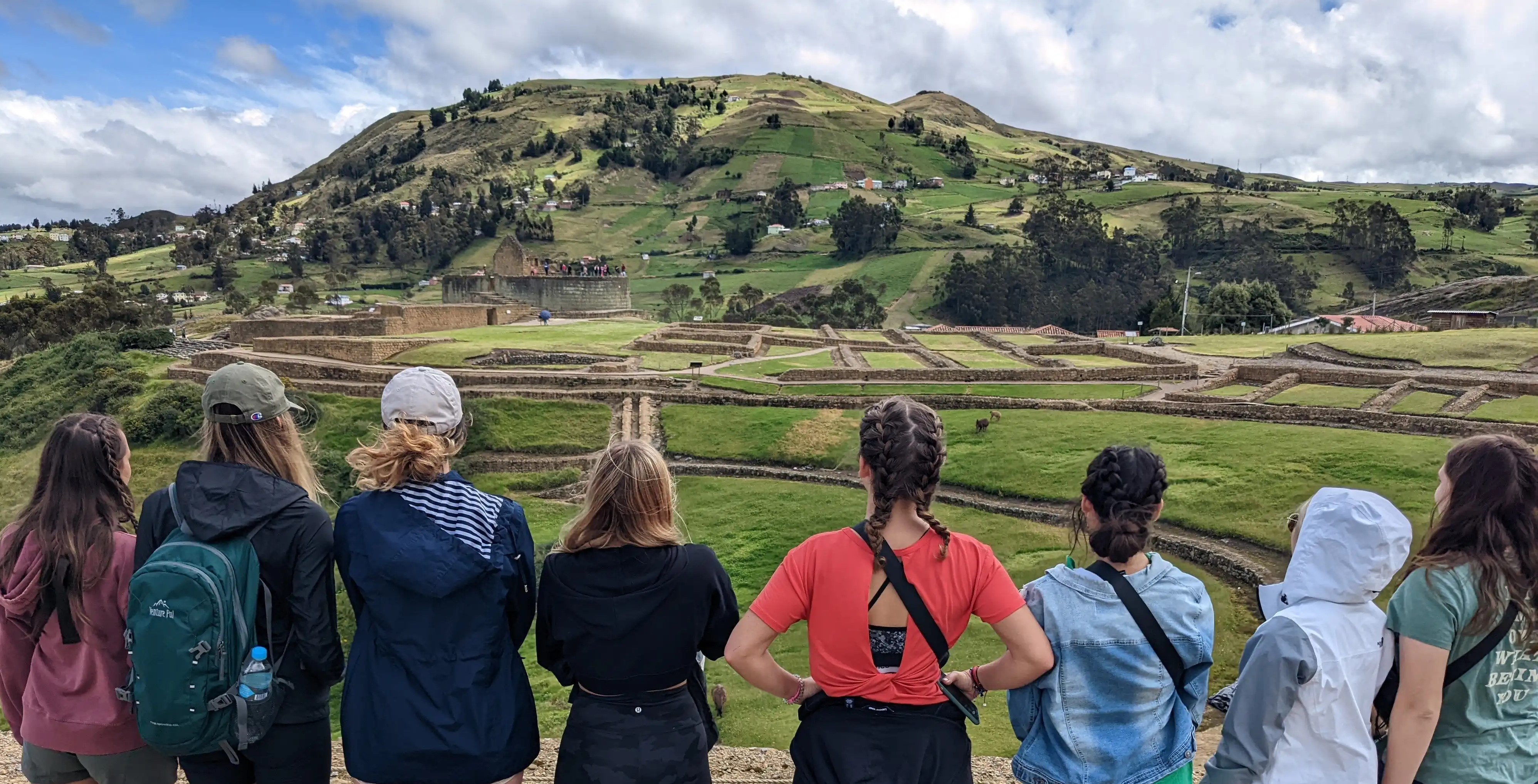 7 female students standing in front of South American landscape