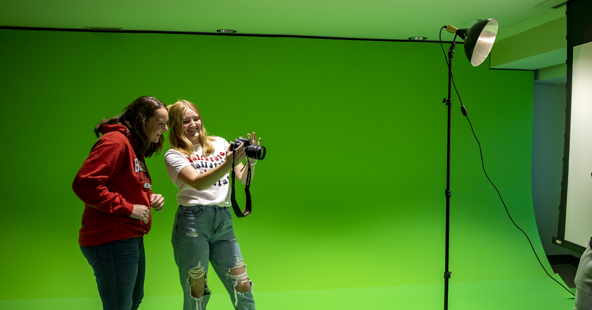 Students getting ready to take picture in front of green screen