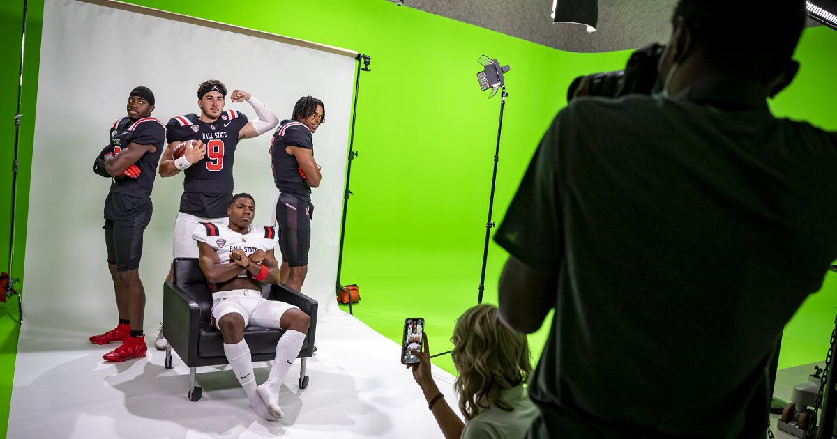 Students at photoshoot with football team