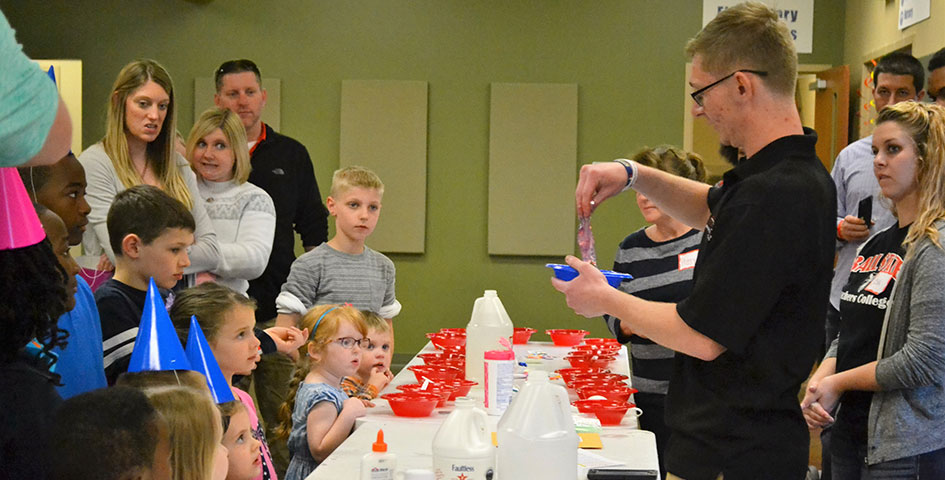 A student giving a demonstration in front of children.