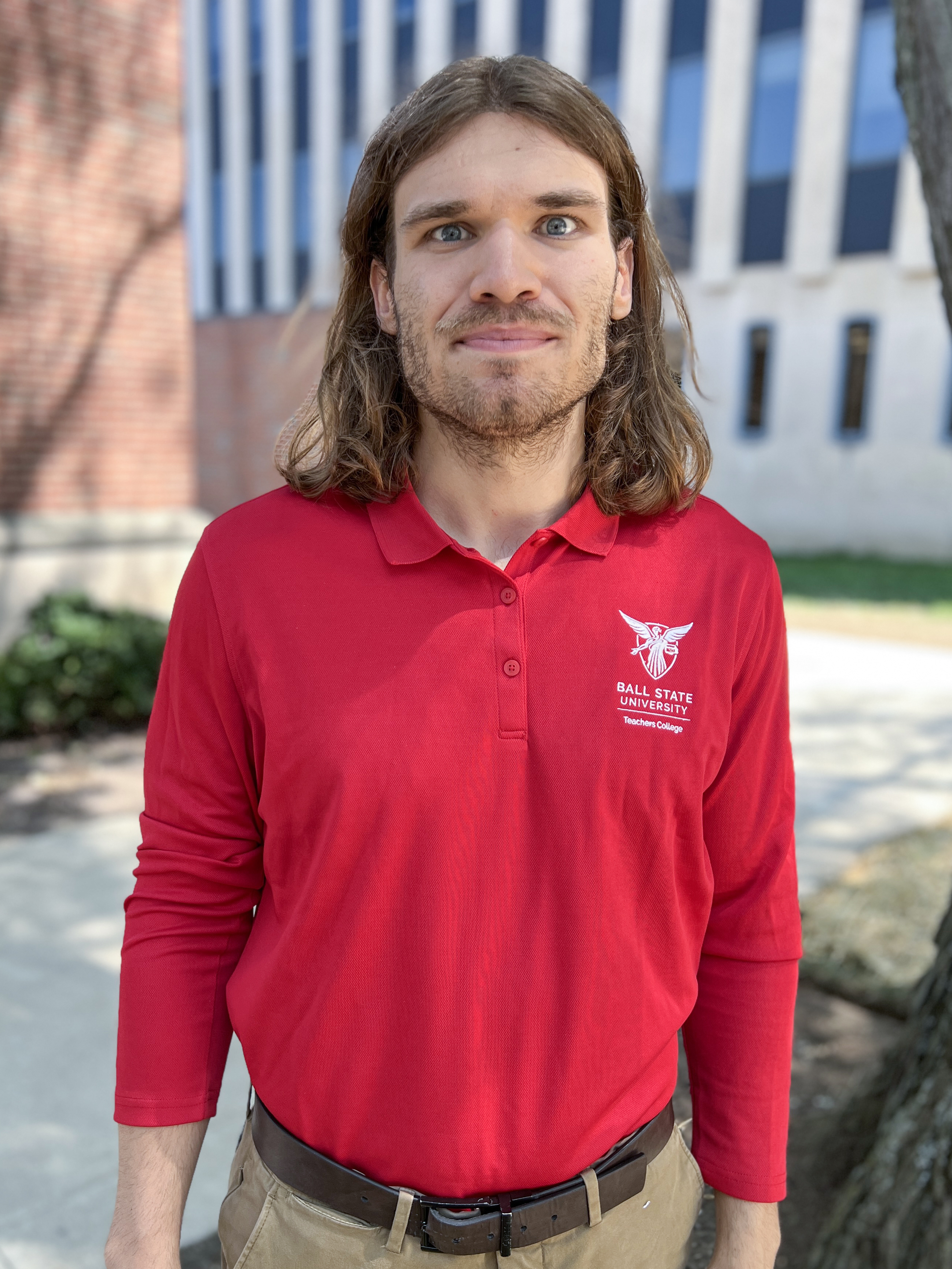 Headshot of a man standing in front of the Teachers College building on the Ball State University campus.