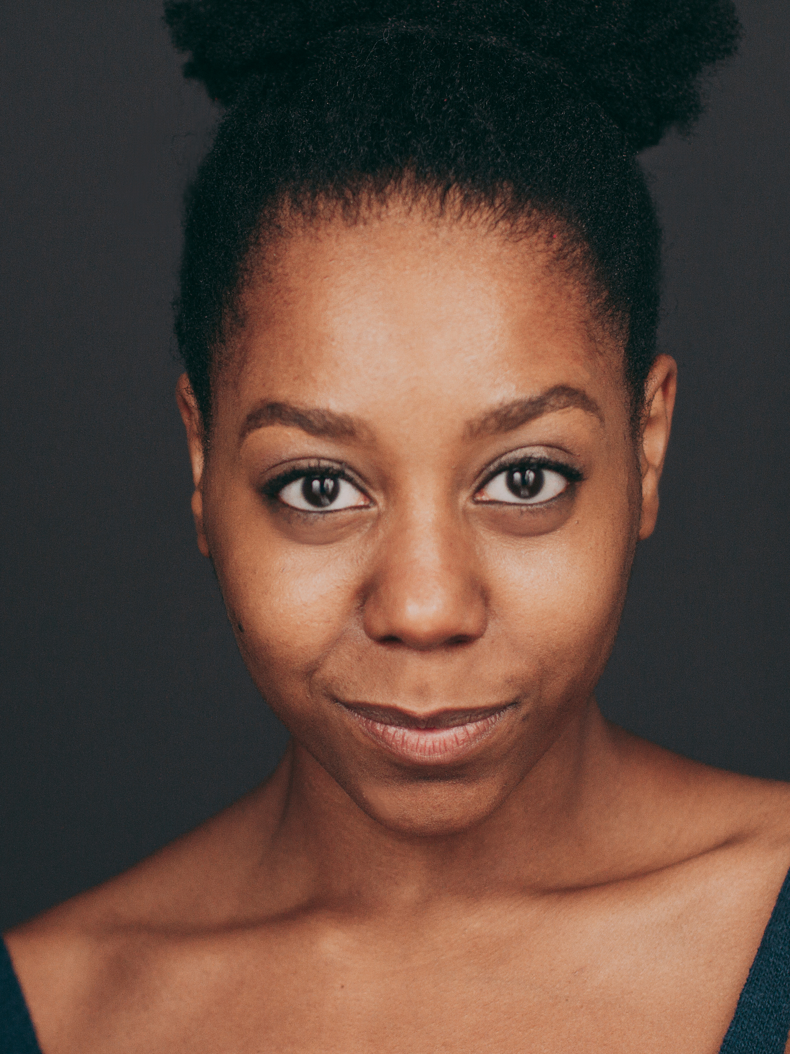 Photo of Zariya Butler. A Black/African American Female with long black hair and wearing a tan T-Shirt.