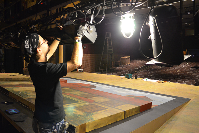 student adjusting the lighting on stage