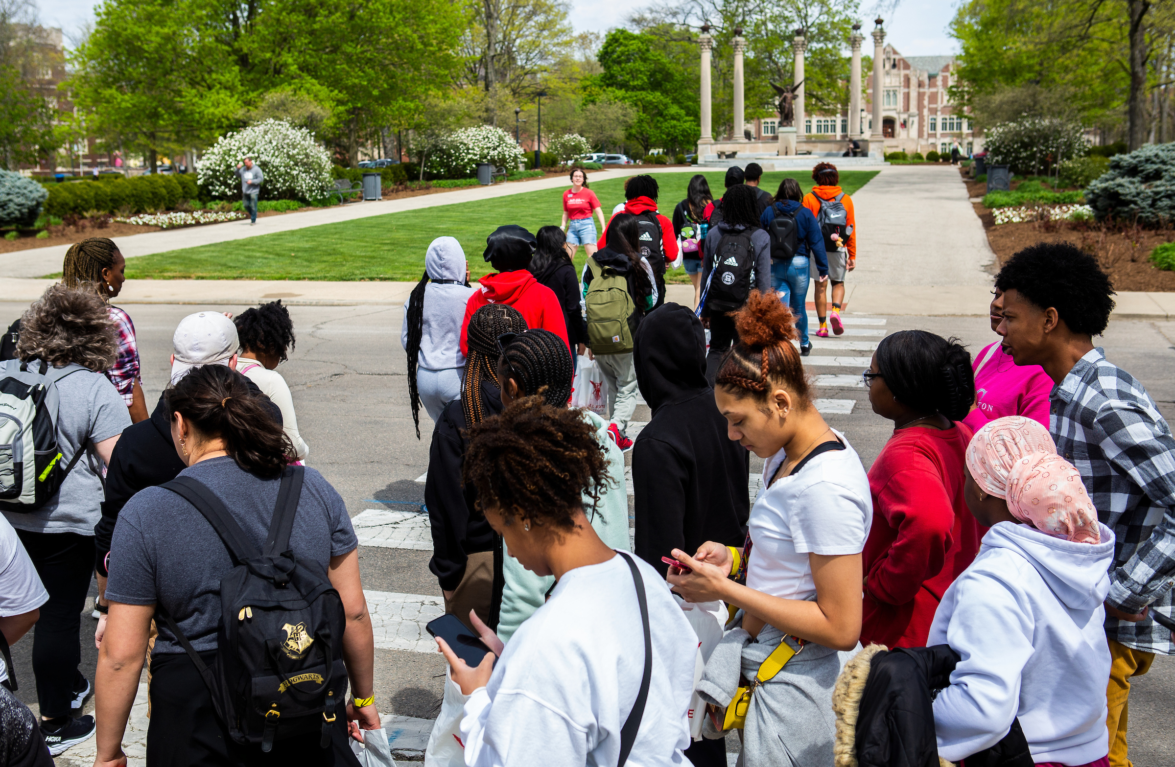 A group of prospective students walking toward the Beneficence statue on Ball State's campus for a tour