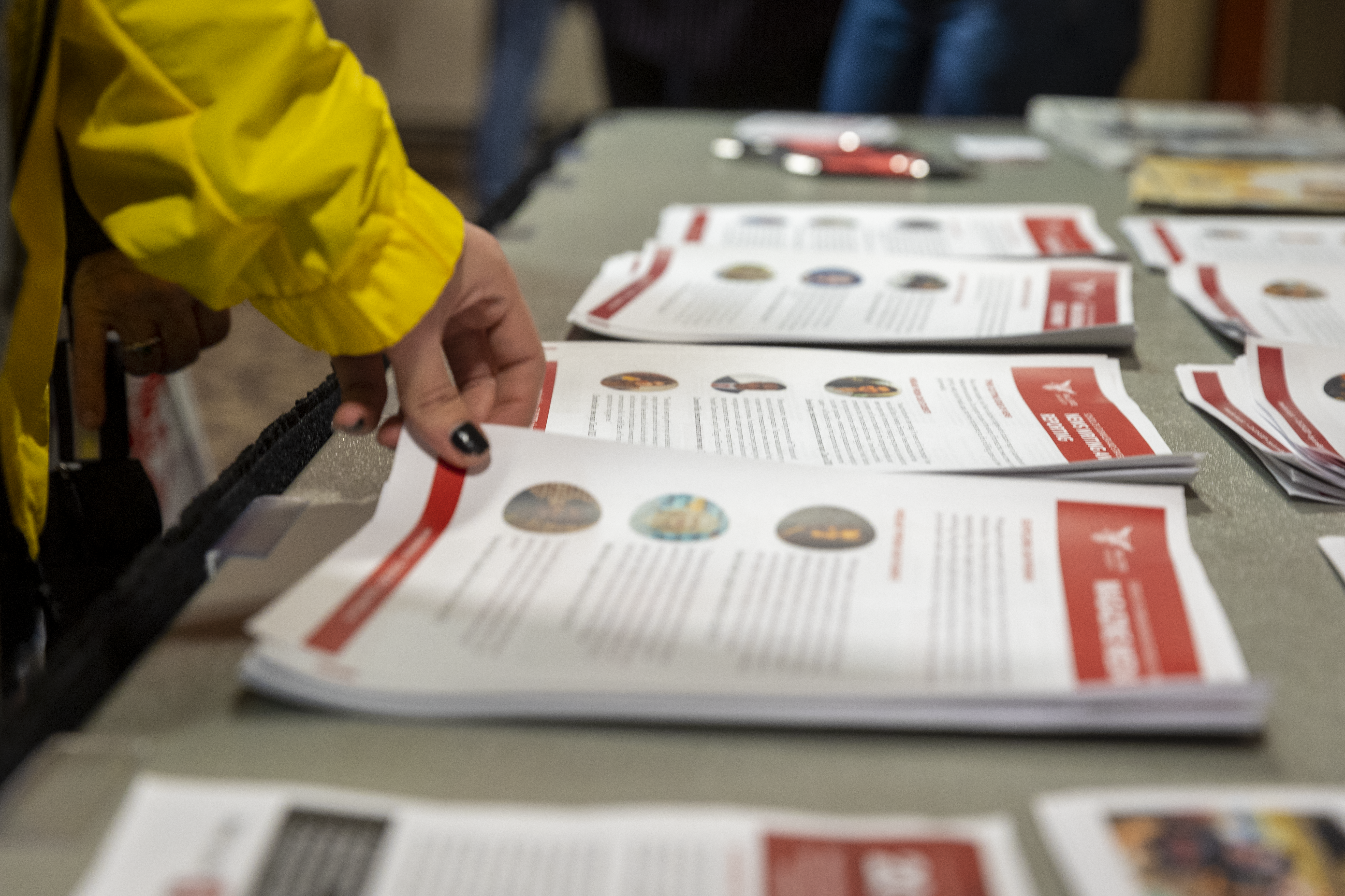 Paper handouts sitting on a table for attendees to grab as they walk by