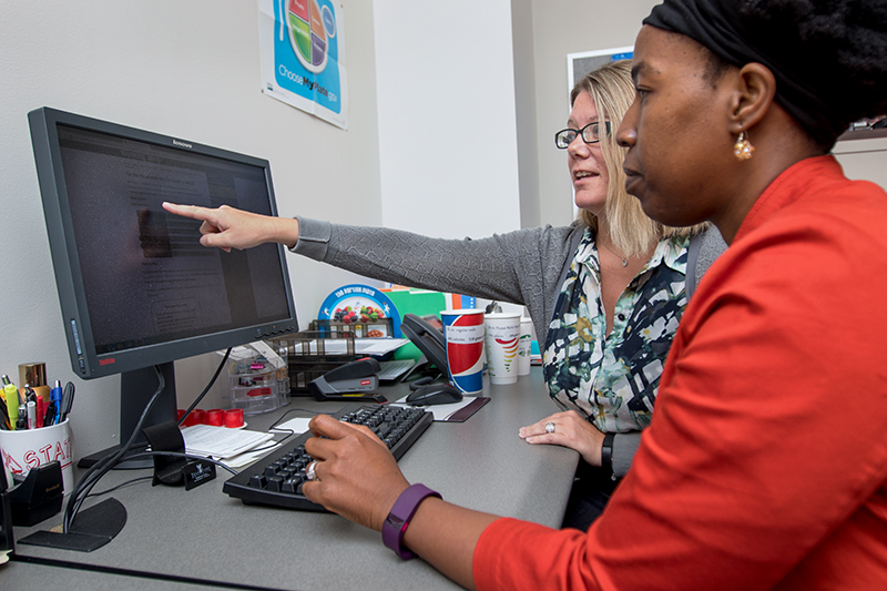 Working Well staff assisting Ball State employee at a computer