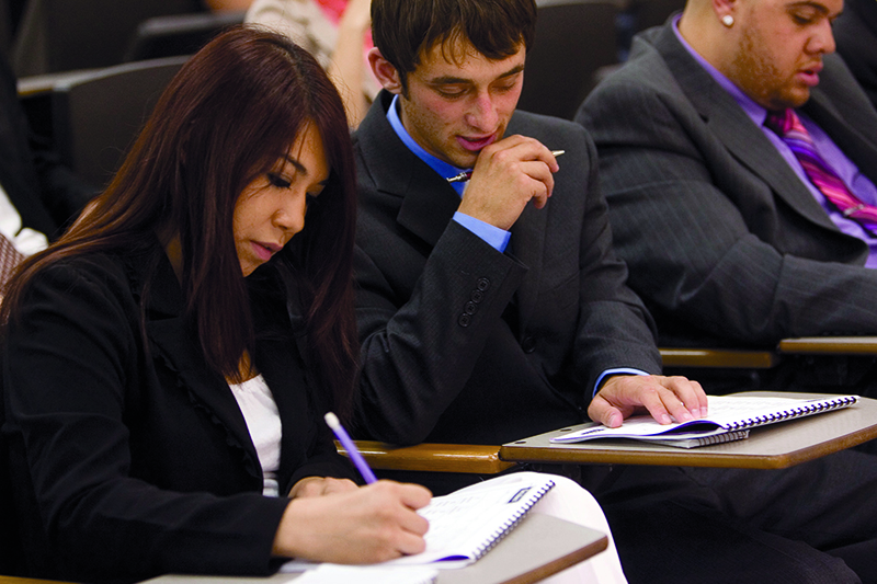 Busines students taking notes during class