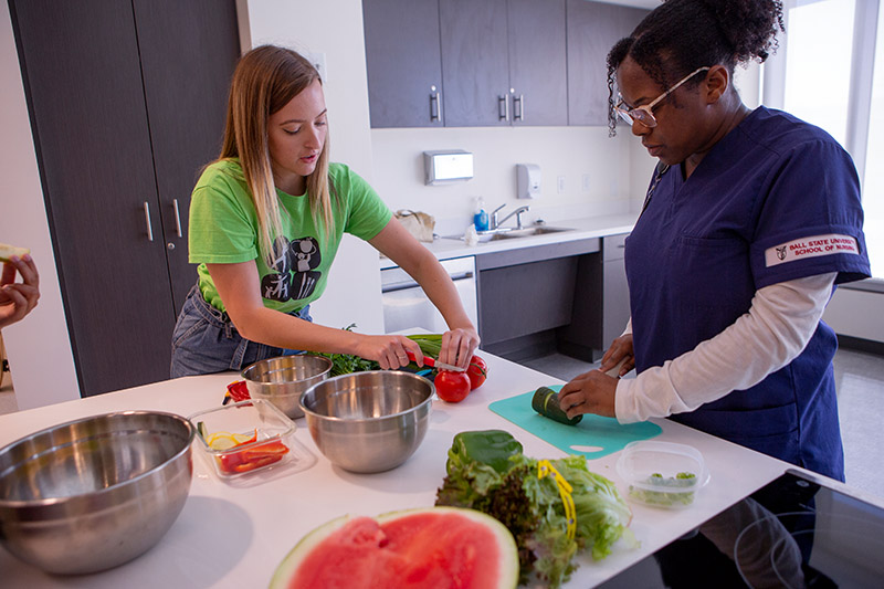 Students work to chop up vegetables in the Welcome Home Suite