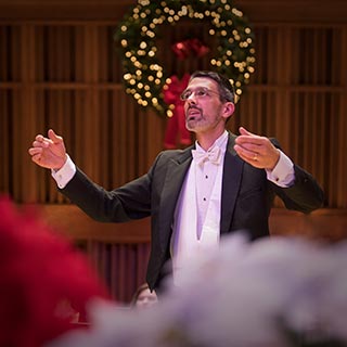 Conductor Andrew Crow leading the choral ensembles on the Holiday Choral Concert