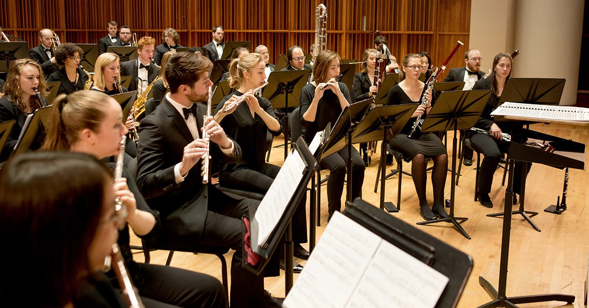 Members of a concert band performing on stage