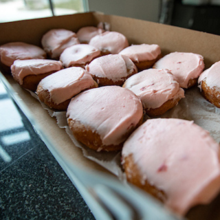 box of donuts with pink icing