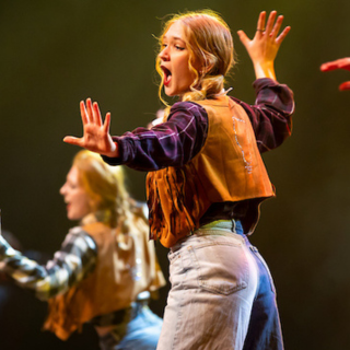 Ball State student dancing and lip singing on stage at Air Jam during Homecoming week