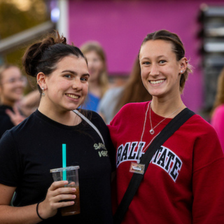 Two Ball State students smiling taking a photo at the Food Truck Festival during Homecoming week