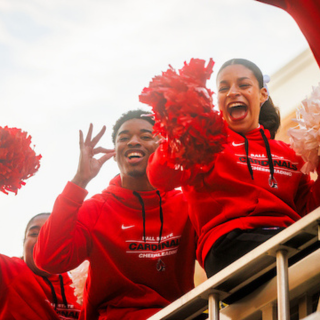 Ball State cheerleaders sitting on a firetruck riding in the Homecoming Parade