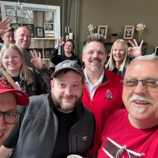 People gathering at local coffee shop in Ball State gear while chirping