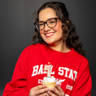 Ball State student holding a cupcake with a number 7 candle