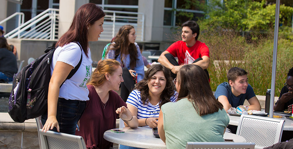 students gathered at a table outside the Atrium food court