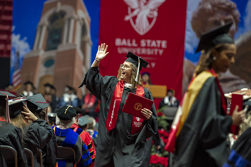 graduate with diploma waving at Fall Commencement 2018