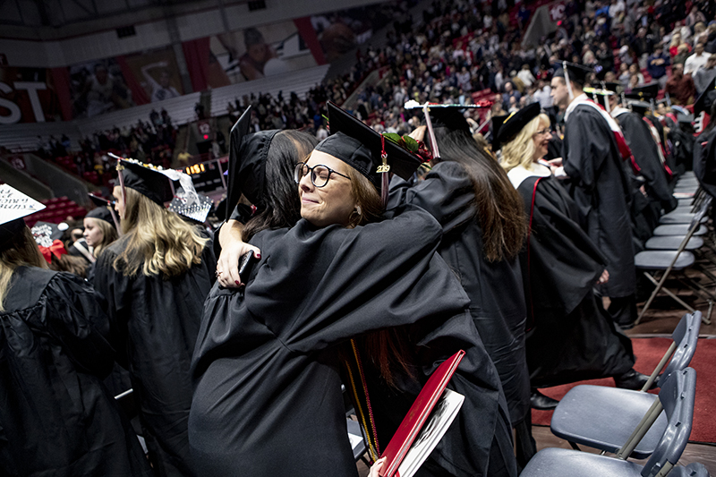 graduates hugging at Fall Commencement 2019