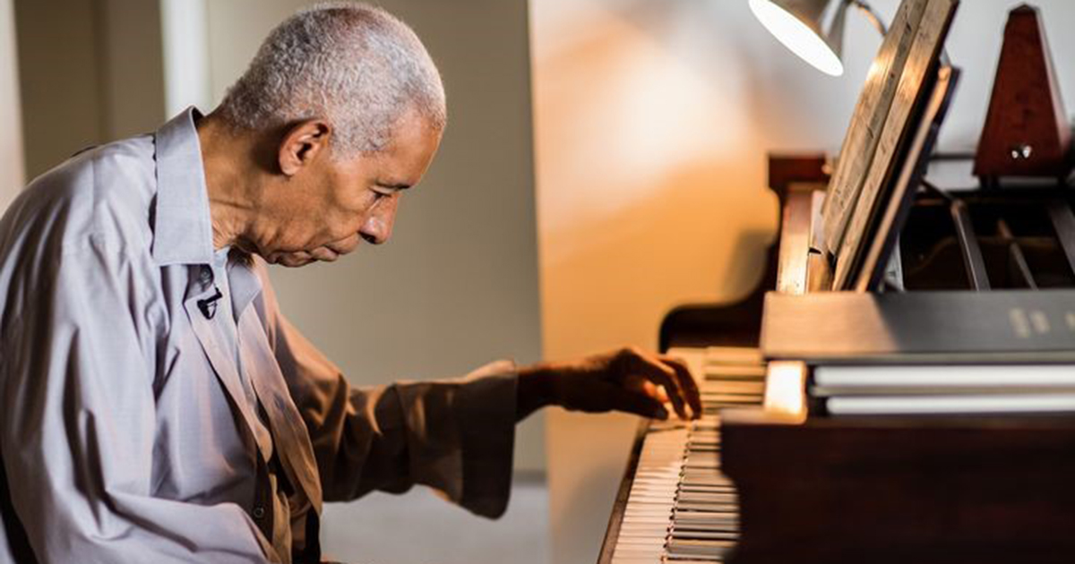 Norman Malone plays piano in his Chicago home.