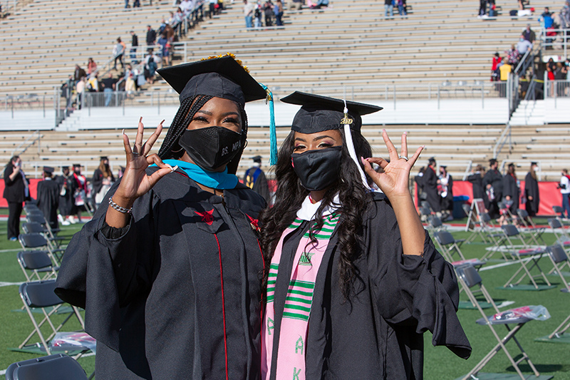 two graduates pose for picture