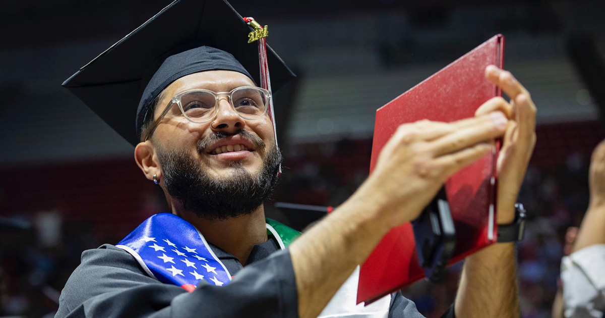 Clapping graduate holding their diploma