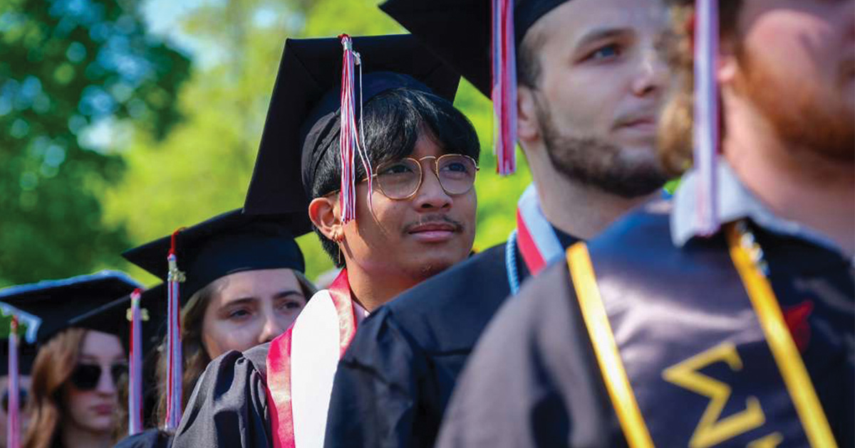 Graduates in a line focusing on one in the middle