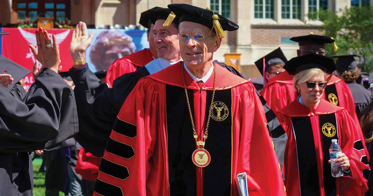 Commencement platform party entering President Mearns in front, Hugh Jackman and others behind